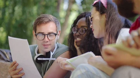 Students discussing group project sitting outdoors Stock Footage 93569688
