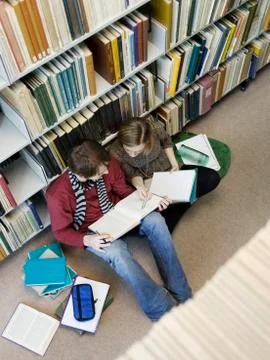Students Doing Homework On Floor In Library Stock Photos