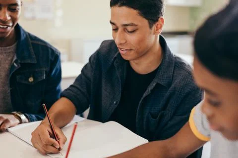 Students doing their studies together at a table Stockfoto's