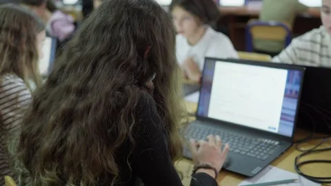 Students engaged in a collaborative computer lesson in a modern classroom e.. Stockbeeldmateriaal 347163076