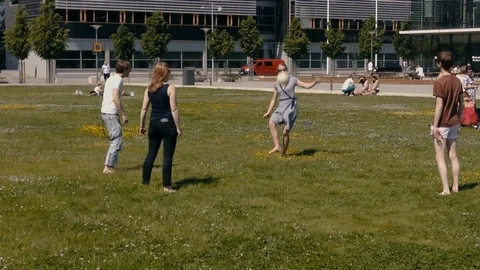 Students enjoy a break from their studies by kicking a soccer ball around 库存影片 99939095