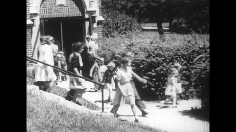 Students exit their school and do roll call with their teacher while waiting Stock Footage 74720555