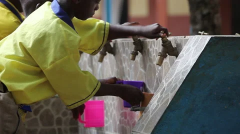 STUDENTS FILL UP BRIGHTLY COLORED CUPS WITH WATER AT FAUCET Stock Footage 60633499