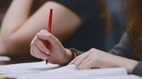 Students focused on tests at desks during exam day in classroom setting Stock Footage 310214116