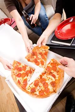 Students: friends reaching in to grab slice of pizza Stock Photos