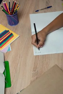 Student's hand doing notes in a copybook. Homework Stock Photos