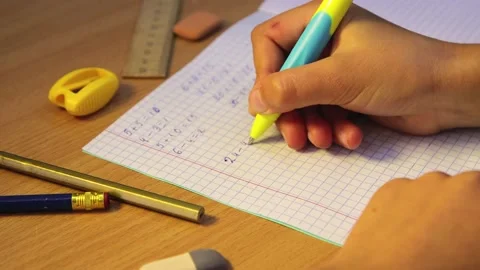 The student's hands solve mathematical examples in a notebook, close-up. Stock Footage 207865800