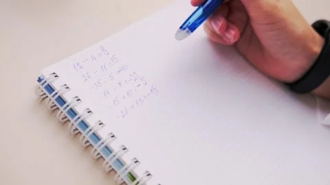 Student's hands writing math problems in notebook on table closeup, academi.. Stock Footage 318894545