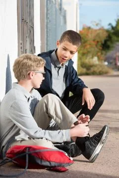 Students hanging out at side of wall talking Stock Photos