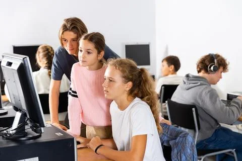 Students help each other solve problems on the computer in classroom 스톡 사진