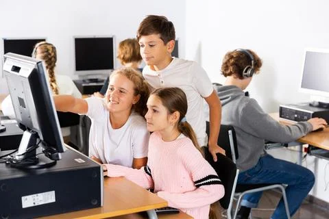 Students help each other solve problems on the computer in classroom 스톡 사진