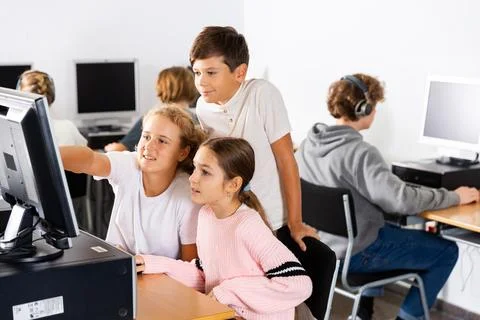 Students help each other solve problems on the computer in classroom 스톡 사진