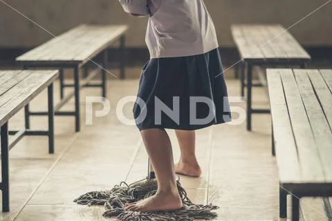 Students help to rub the floor in the canteen Stock Photos