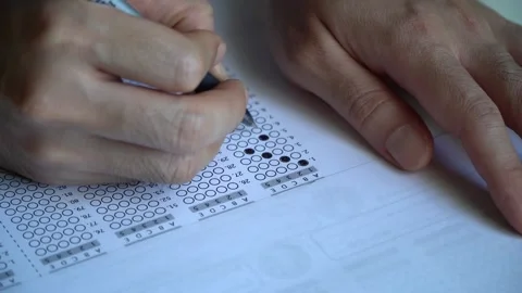 Students hold a pencil and write their choice on the answer sheet and math .. Stock Footage 240112323