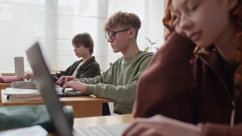 Students Intently Typing on Laptops at Their Desks During class Stock Footage 337394186