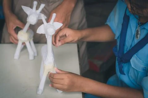 Students learn to make paper mache art as a giraffe in school. Stock Photos