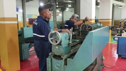 Students Learning Lathe Machine Operation in Industrial Workshop Stock Footage 318951151