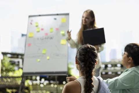 Students listen to strategy plan presentation on whiteboard after class Stock Photos