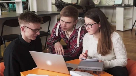 Students looking at laptop screen and discussing something in classroom Stock Footage 85906515