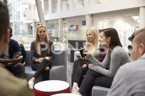 Students Meeting In The Foyer Of Modern University Building