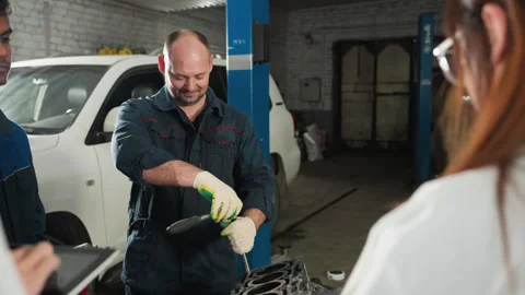 Students Observe Mechanic Demonstrating Spanner Use on Car Engine Stock Footage 303064759