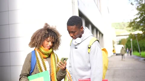 Students outside the university looking at the smartphone and talking Stock Footage 285117950