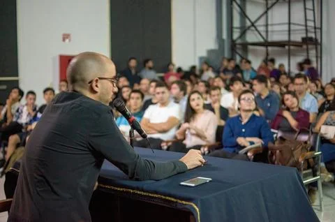 Students paying attention to a lecture given by a woman, projecting about books Foto stock