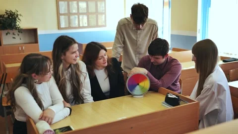 Students in physics class spin Newton's colorful wheel. Stockbeeldmateriaal 258797534