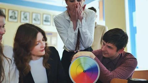 Students in physics class spin Newton's colorful wheel. Stock Photos