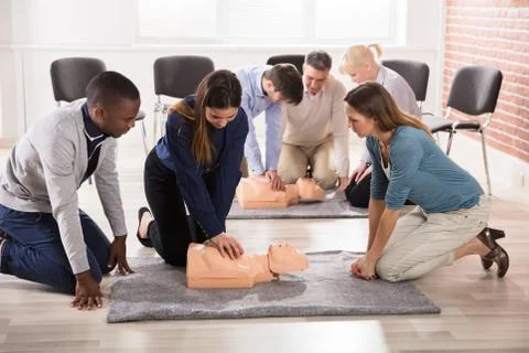 Students Practicing CPR Chest Compression On Dummy Stock Photos