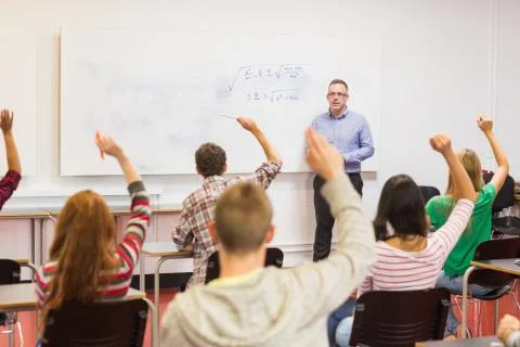 Students raising hands in the classroom Stock Photos