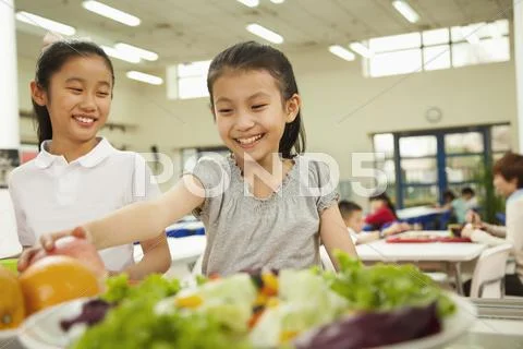 Students reaching for healthy food in school cafeteria Stock-Fotos