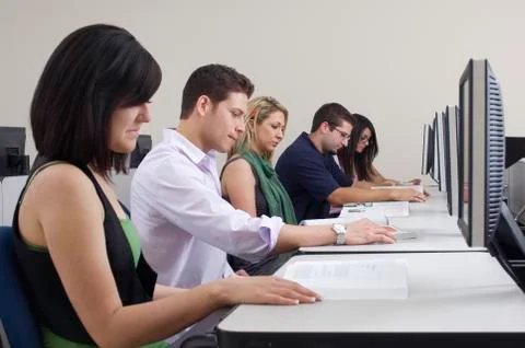 Students Reading Books In Computer Lab Stock Photos