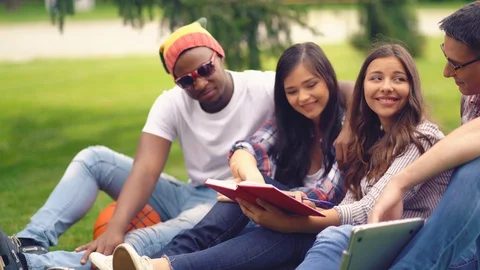 Students reading studdy books sitting outdoors Stock Footage 130054569