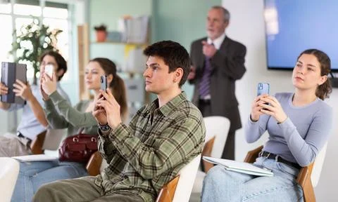 Students scan the QR code on their mobile phone during the lecture Stock Photos