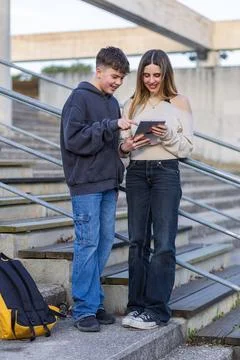 Students sharing digital tablet during campus break Stock Photos