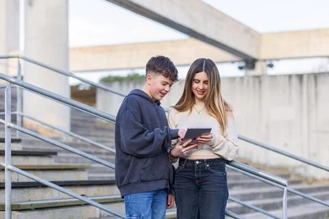 Students sharing tablet on campus stairs learning Stock Photos