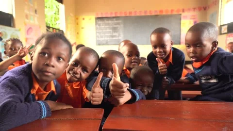 Students showing thumbs up to camera in rural school in Africa Stock Footage 230078362