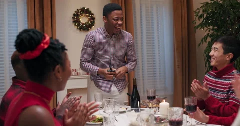 Students sit at the festive table, eat and chat. Guy of African appearance in Stockbeeldmateriaal 218270897