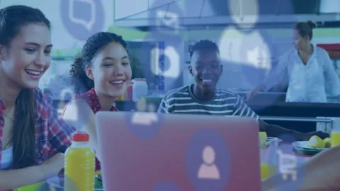 Students sitting cafeteria table tapping pink laptop, sharing with education app Stock Footage 329931403
