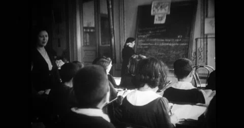 Students sitting in classroom and girl reading on blackboard Stock Footage