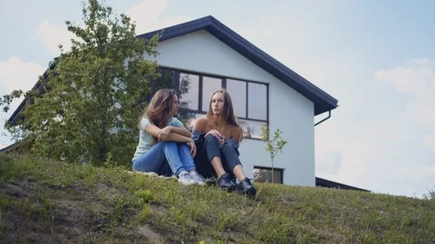 Students sitting on grass in the park and talking. Group of young people Stock Footage 115114418