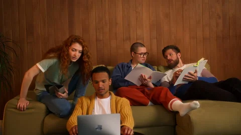 Students on sofa use laptop, tablet and notebooks Stock Footage 267825106