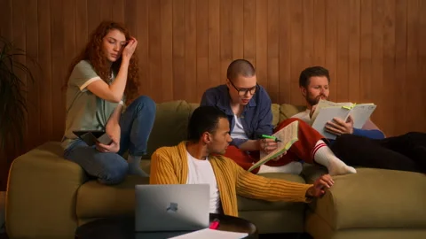 Students on sofa use laptop, tablet and notebooks Stock Footage 267825861
