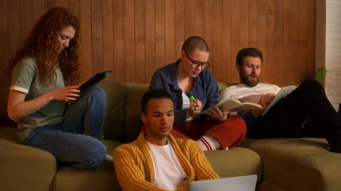 Students on sofa use laptop, tablet and notebooks Stock Footage 267827567