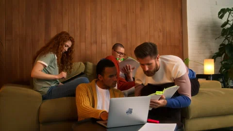 Students on sofa use laptop, tablet and notebooks Stock Footage 267828470