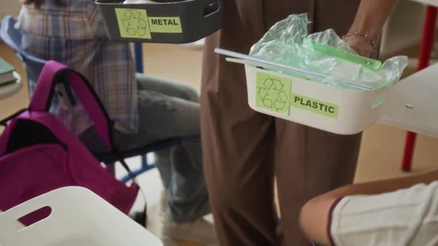 Students Sorting Plastic Waste into Recycling Bins with Teacher Stock Footage 345240741