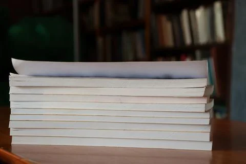 Students study with a stack of notebooks in a library during the afternoon 写真素材
