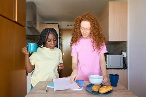 Students studying and having breakfast in the kitchen Stock Photos