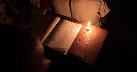 Students Studying in a class by candlelight and kerosene lantern in Mbale . Stock Footage 119152568